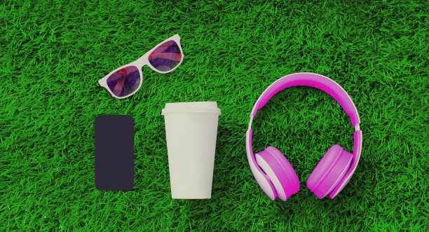 粉色耳机，黑色空白复制空间屏幕智能手机，咖啡杯，绿色草地背景太阳镜，俯视图，平躺图片下载
