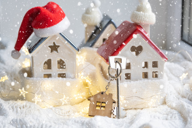 钥匙的房子与钥匙链上一个舒适的家与圣诞装饰。新年、圣诞节的礼物。建筑，设计，工程，搬迁到新房子，抵押，租赁和购买房地产图片下载