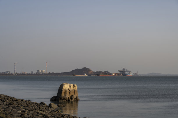 海岸线和远处的化工厂图片下载