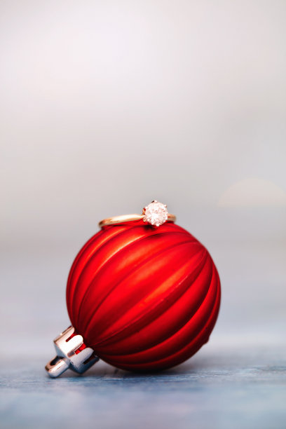 红色的圣诞装饰，上面有一枚金钻石订婚戒指。空间的文本图片下载