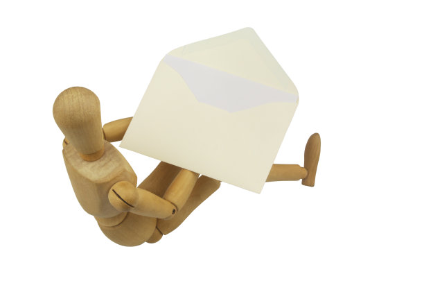 木制假人拿着信封与信隔离在白色背景。图片下载