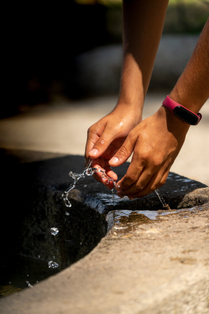 用喷泉里的水来提神的手图片下载