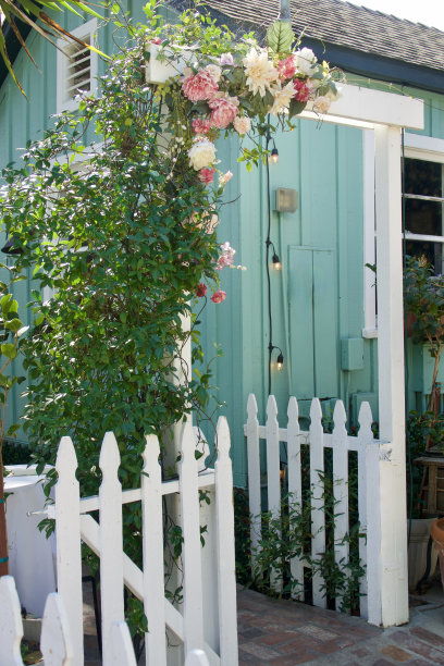 农舍花园，白色尖桩篱笆和玫瑰覆盖的凉亭图片下载
