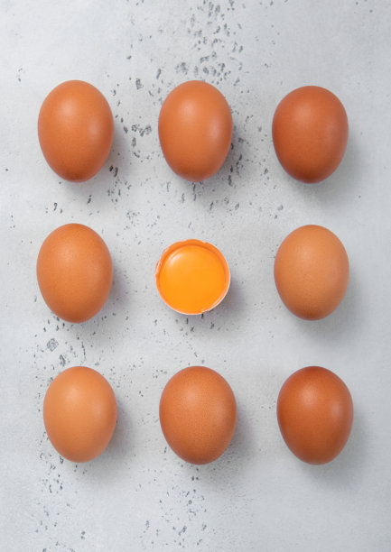 概念生的新鲜鸡蛋与壳和蛋黄在灯光厨房背景。图片下载