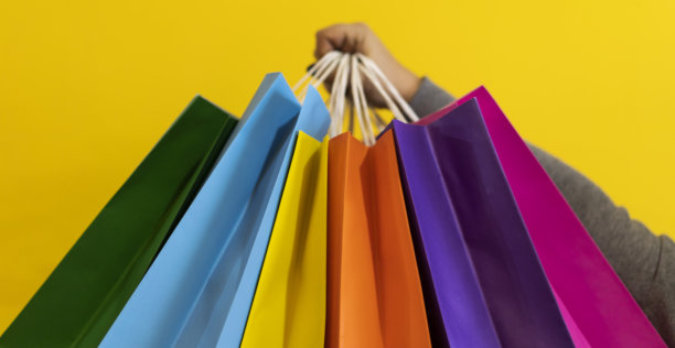 特写一个女人的手拿着五颜六色的购物袋。副本的空间。购物的概念图片下载