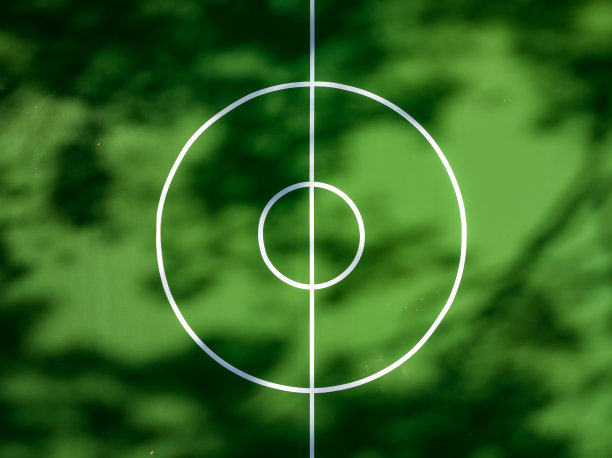 学校操场上绿色和红色的户外篮球场的航拍照片。场地包括挡土墙和黑色乙烯基涂层链环围栏。图片下载