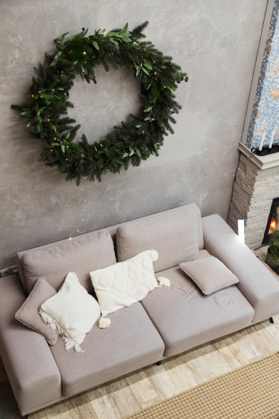 现代客厅内部灰色沙发和圣诞花环在墙上，图片下载