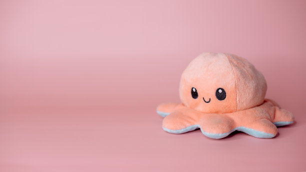 粉色背景上的粉色章鱼玩具图片下载