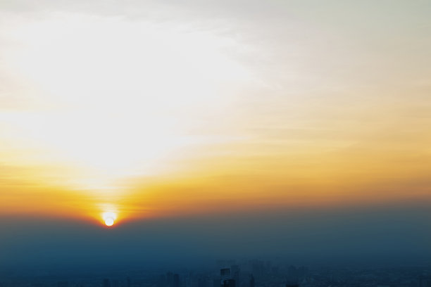 傍晚的日落在一个大城市，壮丽的全景风景的日落与云，没有焦点，具体。图片下载