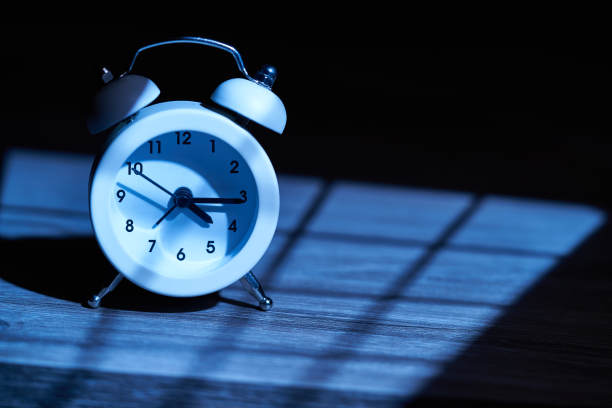 复古闹钟在黑暗的夜晚被窗户的光线照亮图片下载