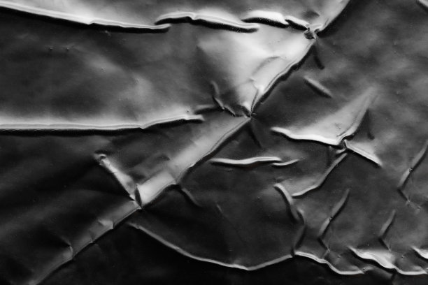 黑色皱褶和折痕塑料海报纹理背景图片下载