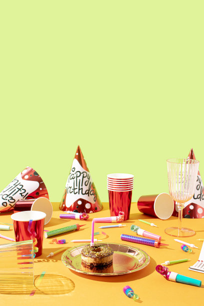 创意生日派对的帽子，纸吸管，糖果，气球吹风机和五彩纸屑的概念。彩色的背景。图片下载