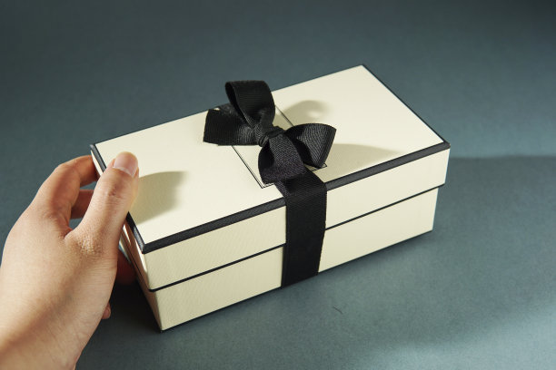 手拿着一个绿色背景的礼品盒。图片下载