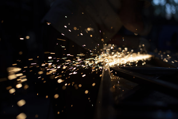 金属研磨。摩擦产生火花。黑暗中的灯光。局部火灾的混乱飞行。图片下载