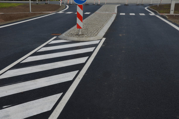 在靠近中心的滚动窗台上铺上灰色花岗岩方块的圆形路面。斜面的混凝土路缘，一个交通枢纽，圆圈中间有花草。常年花圃图片下载