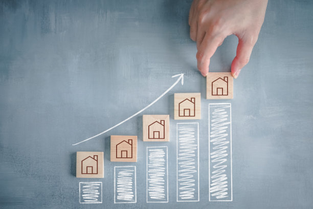 房地产概念。物业投资、资产管理、贷款按揭、房产税、销售价格。上升箭头显示利率或价格的增加和手从最高的柱状图选择房子。图片下载