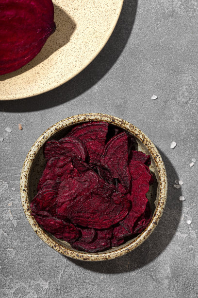 灰色背景下碗里的甜菜根片。健康蔬菜片，素食者的零食俯视图，垂直照片图片下载