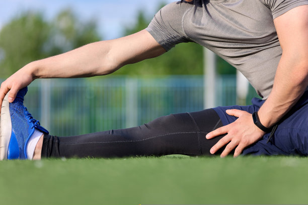 在户外运动场上伸展时的运动员脚特写图片下载
