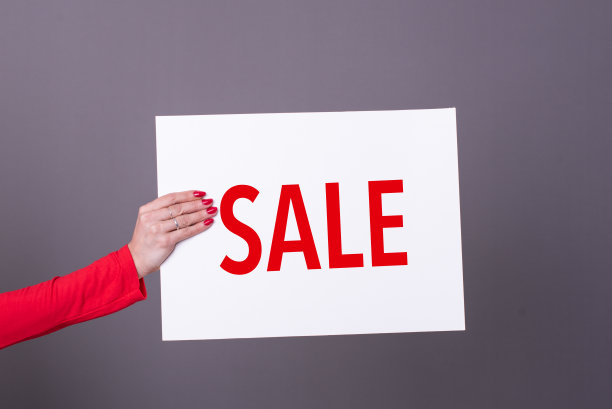 女性手拿促销海报。影棚拍摄。商业概念。图片下载