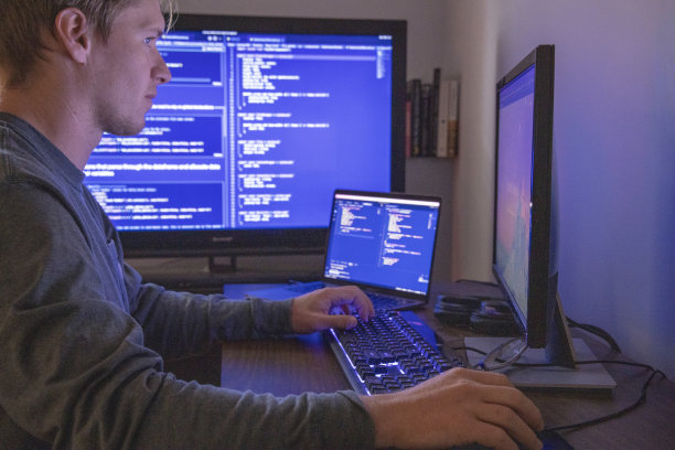 年轻人在开发网站时使用多台电脑图片下载