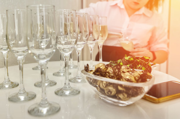 女服务员把起泡的白葡萄酒分发给客人。图片下载