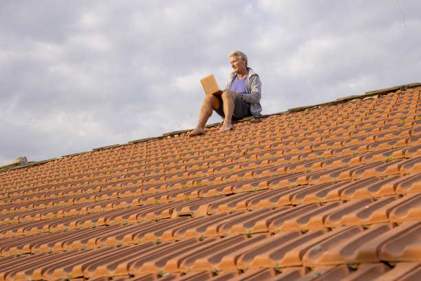 老人在屋顶上使用笔记本电脑图片下载