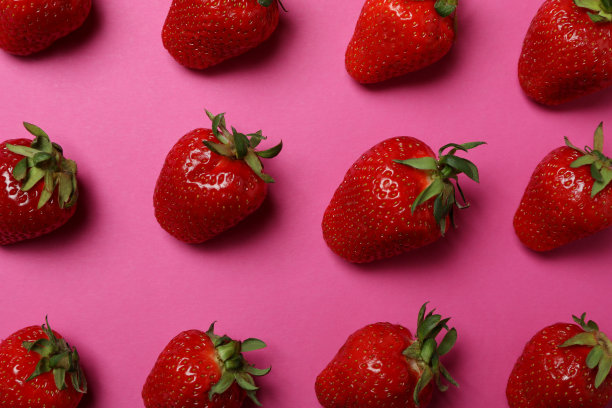 新鲜美味的草莓，粉色背景的叶子图片下载