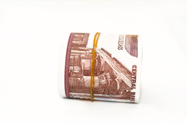 埃及钞票卷磅孤立在白色背景上，50勒50埃及镑现金纸币用橡皮筋卷起来，上面有Abu Hurayba清真寺，Edfu神庙和带翅膀的圣甲虫的形象图片下载