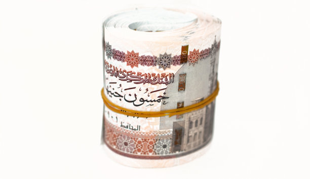 埃及钞票卷磅孤立在白色背景上，50勒50埃及镑现金纸币用橡皮筋卷起来，上面有Abu Hurayba清真寺，Edfu神庙和带翅膀的圣甲虫的形象图片下载