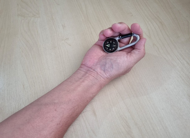 小指南针放在木地板上这是一个可以引导你旅行和探索新地方的装置。精确的图片下载