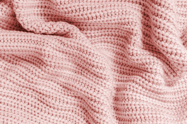褶皱折叠针织浅粉色面料质地背景。柔软温暖的编织格纹或毛衣特写。舒适的纺织背景。图片下载