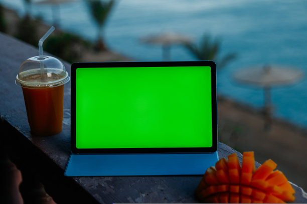 带有海景阳台上的绿色屏幕平板电脑图片下载