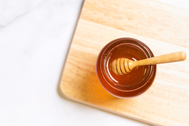 蜂蜜拍摄和木勺大理石托盘与浅灰色背景和复制空间。图片下载