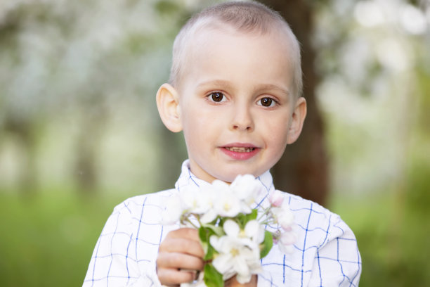 一个快乐的孩子在春暖花开的花园里高兴地笑着。图片下载