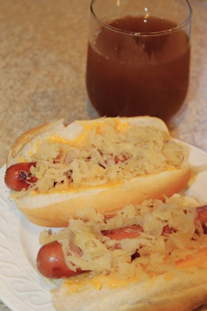 免版税的照片-德国狗与切达奶酪午餐-美味的食物背景为网站，美食博客，或营销应用程序-午餐已经提供-个人视角的两个面包长度的狗与奶酪和酸菜-热狗时间图片下载