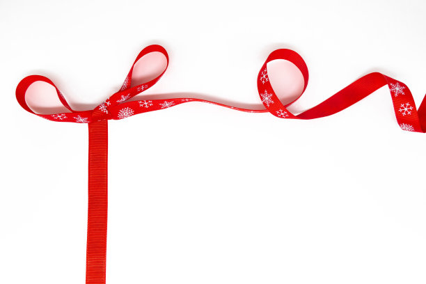 蝴蝶结的红色卷曲明亮的丝带雪花作为框架。白色背景，复制空间。圣诞节、情人节、礼物的概念图片下载