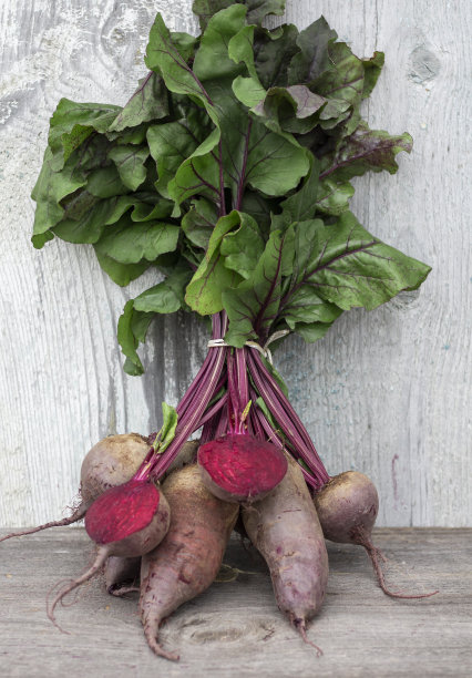 一束洗过的红色甜菜，顶部放在木桌上，垂直照片图片下载