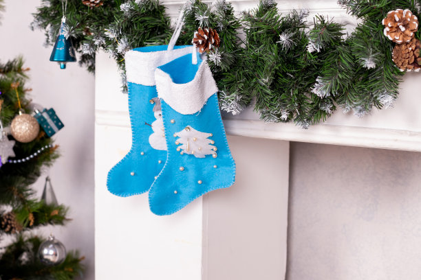节日装饰。蓝袜子当礼物。圣诞袜挂在房间内部的壁炉上。圣诞长袜图片下载