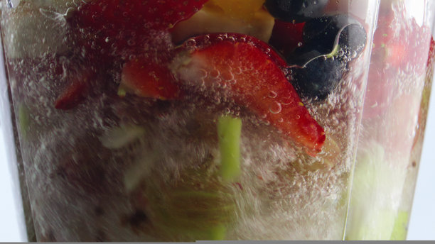 旋转水果浆果搅拌机的超慢动作特写。库克的冰沙。图片下载