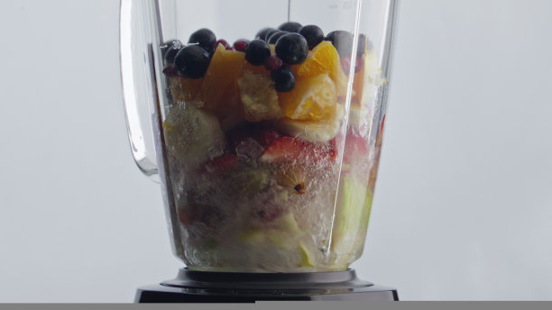 电动搅拌机混合水果浆果与水的自然鸡尾酒特写图片下载