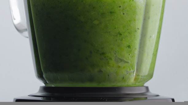 绿色奶昔混合在搅拌器碗里，用超慢动作特写。图片下载