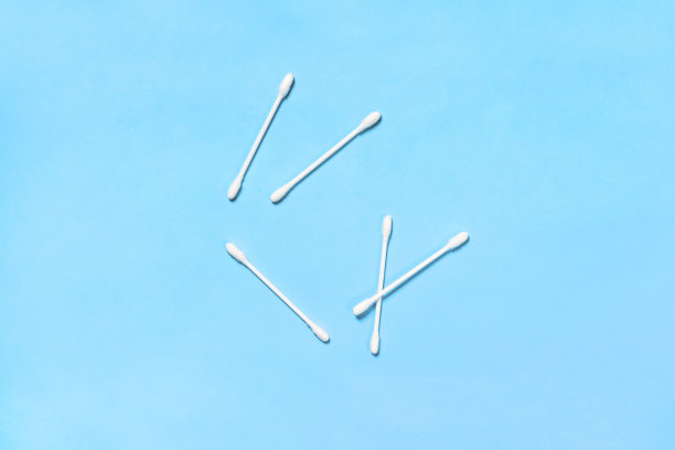 棉花花蕾。白色棉签，俯视图。蓝色背景上孤立的棉棒。图片下载