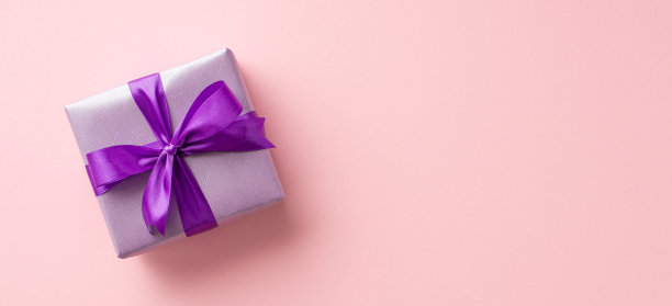 新年的概念。俯视图照片丁香礼物盒与紫罗兰丝带蝴蝶结上孤立的浅粉色背景与copyspace图片下载