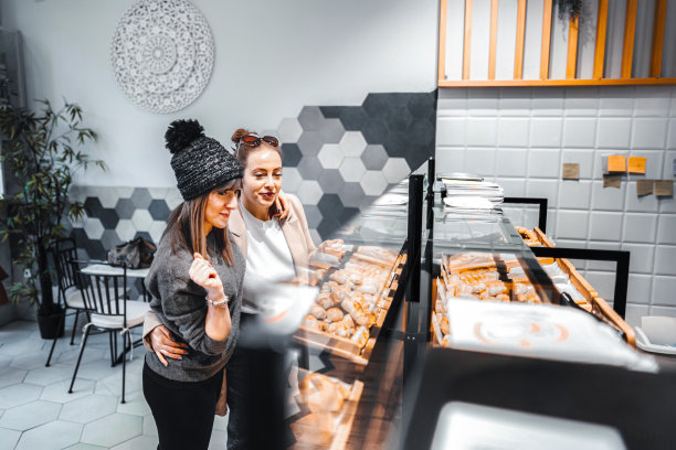 两个女性朋友在挑选新鲜出炉的糕点当早餐图片下载