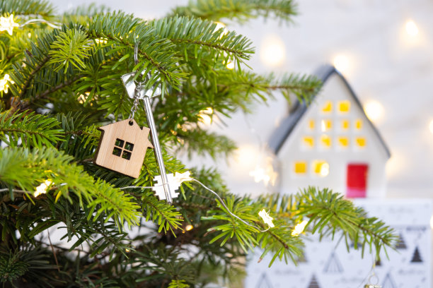 带钥匙链的房子钥匙挂在圣诞树上。新年、圣诞节的礼物。建筑，设计，工程，搬迁到新房子，抵押，租赁和购买房地产。本空间图片下载