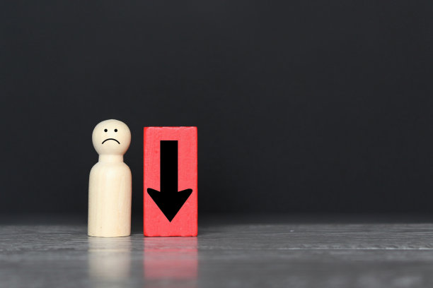 木制洋娃娃和向下的箭头与复制空间。图片下载