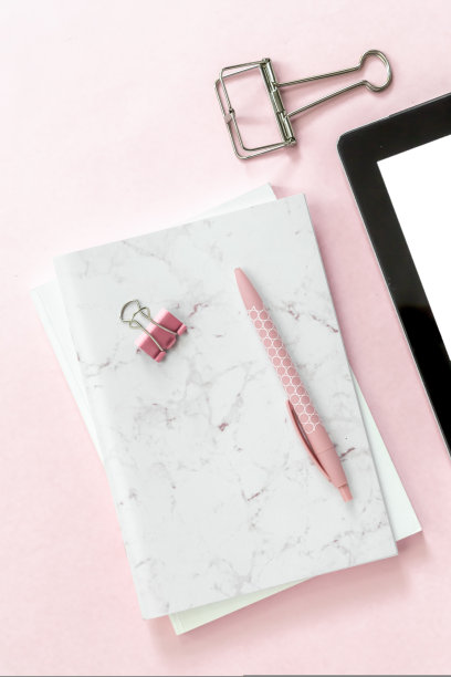 桌面扁平的办公文具项目和空白平板上的粉红色背景图片下载