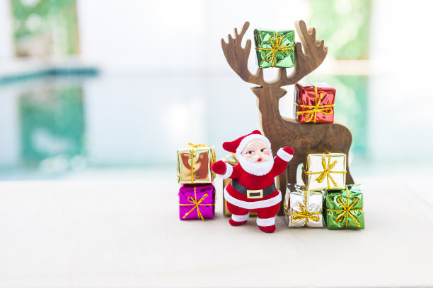 木制驯鹿与圣诞老人和彩色礼盒模糊的背景图片下载