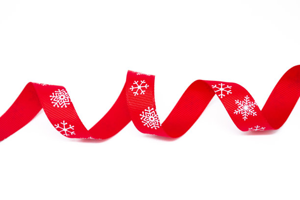 一条白色背景上有雪花的红色卷曲明亮丝带。副本的空间。圣诞节、情人节和礼物的概念图片下载