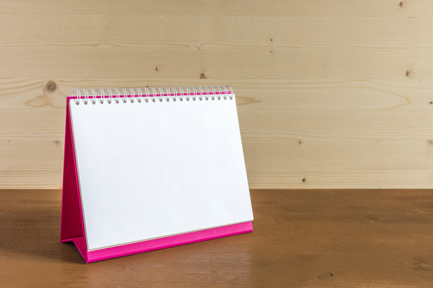 白色空白纸桌子螺旋日历上的木材背景。图片下载